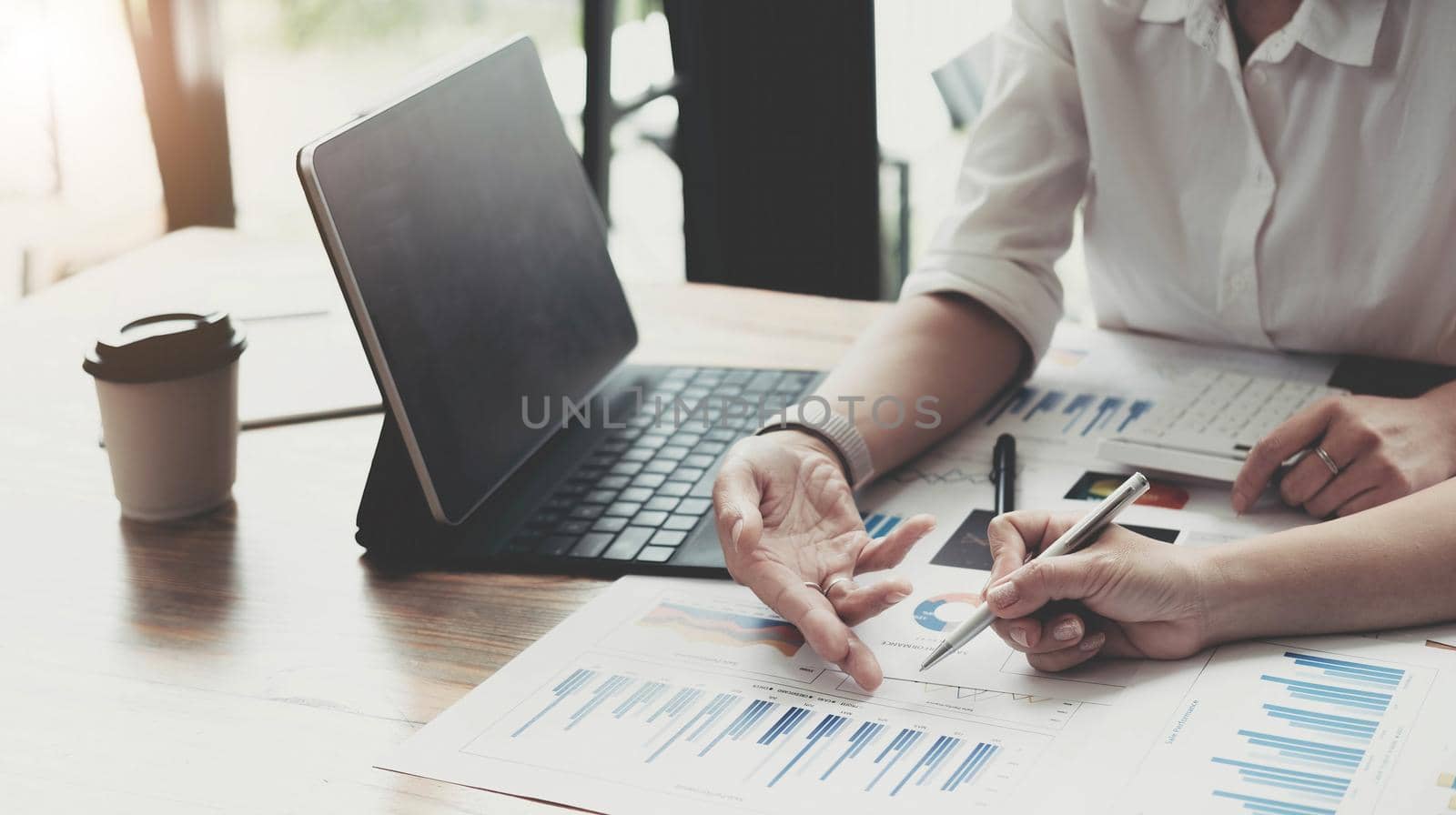 Two accountant discussion analysis sharing calculations about the company budget and financial planning together on desk at the office room by wichayada