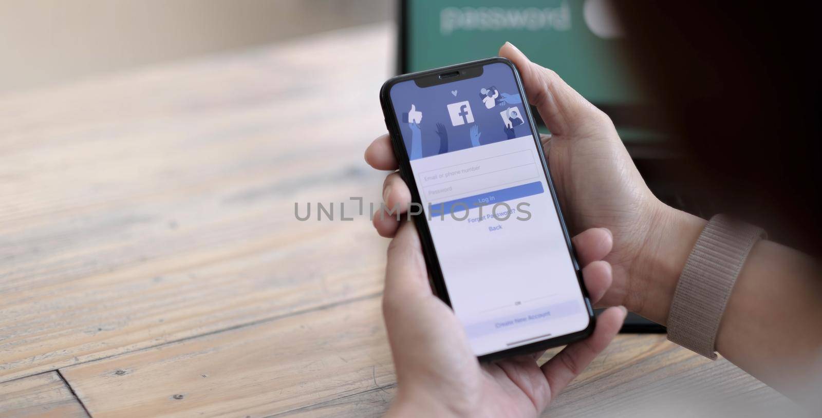 CHIANG MAI ,THAILAND AUG 24 2021: Woman holding a iPhone X with social Internet service Facebook on the screen. by wichayada