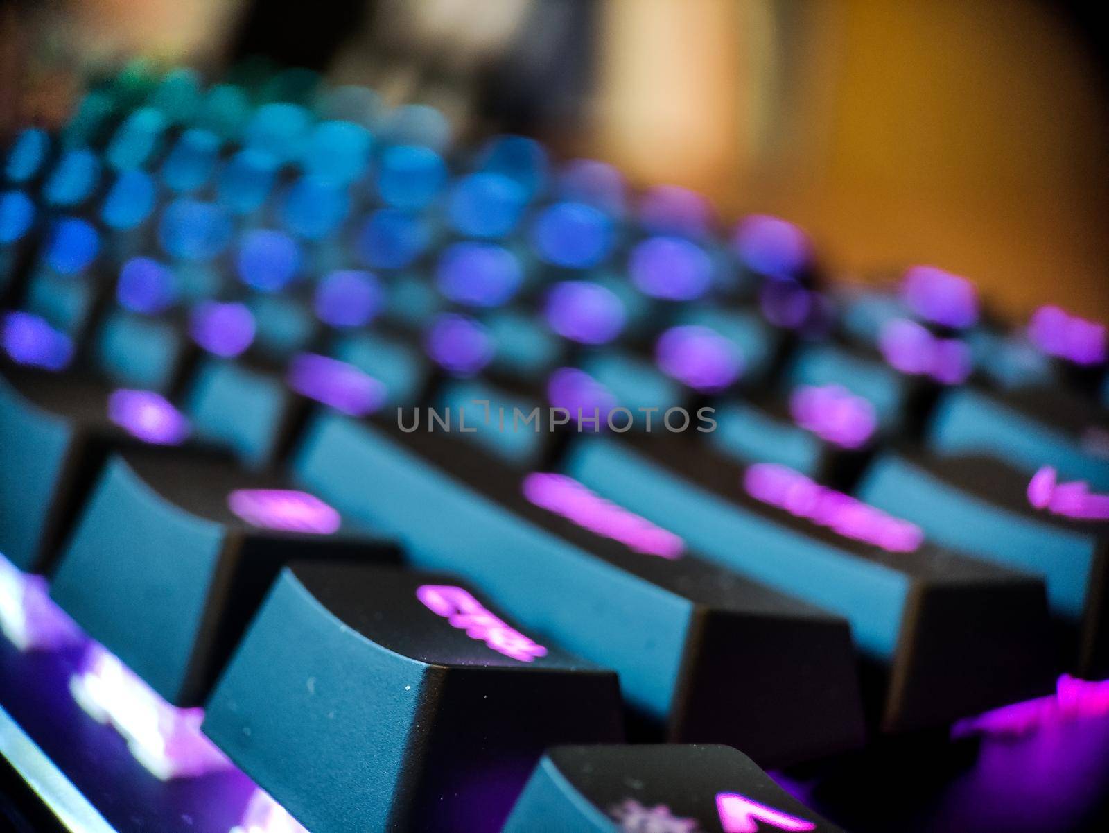 Gamer keyboard with neon backlight macro defocused close up. Online games and virtual reality concept background. High quality photo