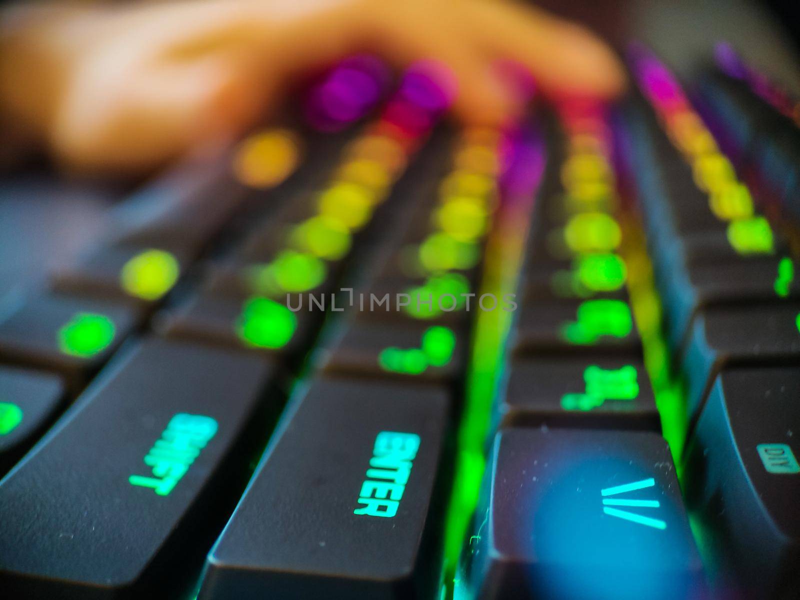 Gamer keyboard with neon backlight macro defocused close up. Online games and virtual reality concept background. High quality photo