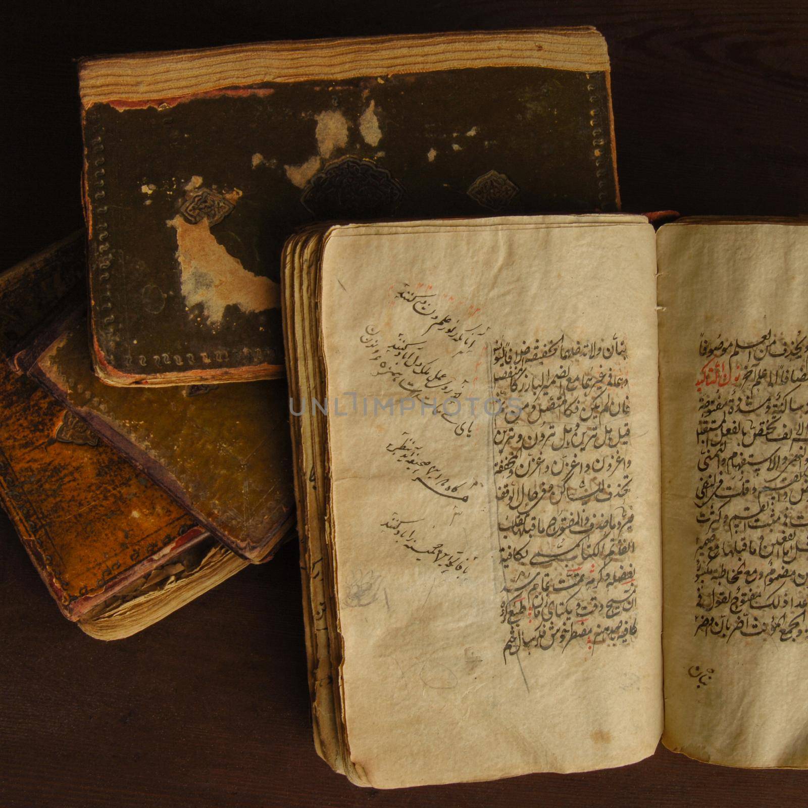 Tashkent, Uzbekistan - August 10, 2009: Stack of open ancient books in Arabic. Old Arabic manuscripts and texts. Top view