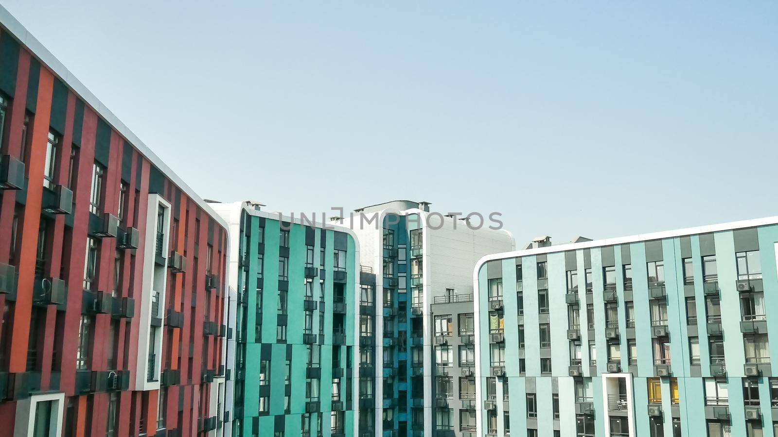 Fragment of new residential complex with buildings exterior, luxury house and home complex on blue sky background. Modern neighborhood concept by balinska_lv