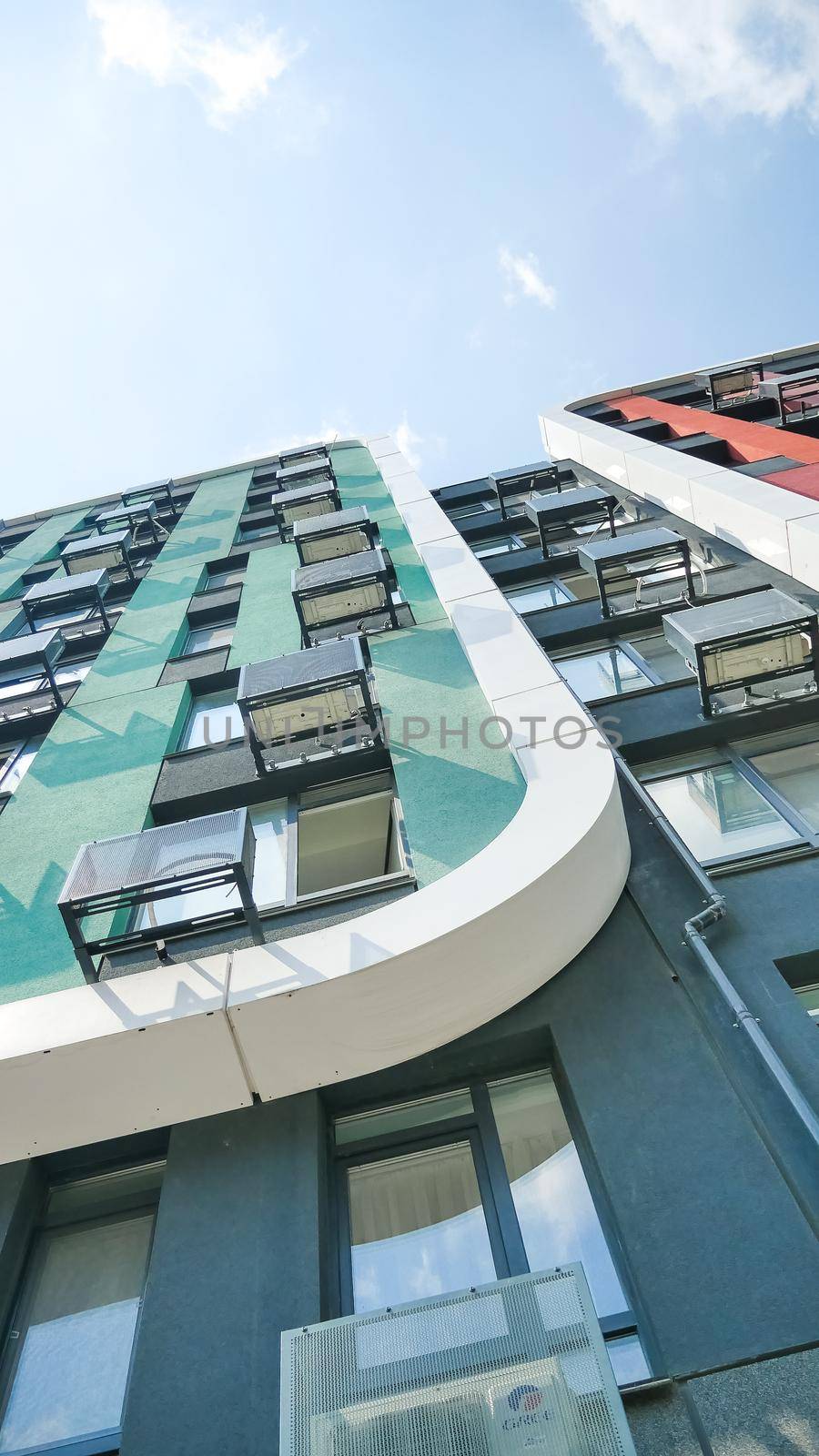 Fragment of new residential complex with buildings exterior, luxury house and home complex on blue sky background. Modern neighborhood concept.