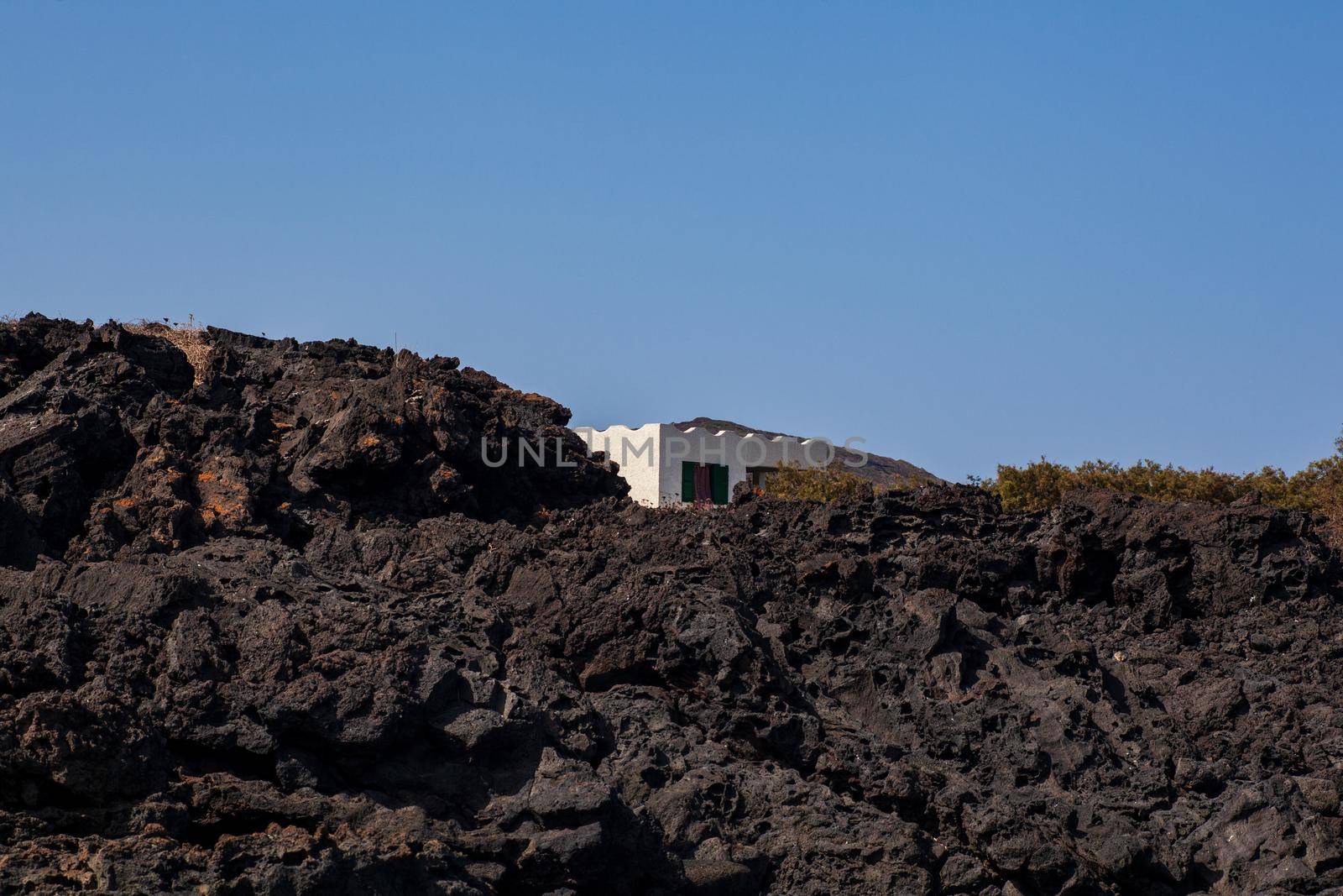 View of white house in the lava hill, Sicily by bepsimage