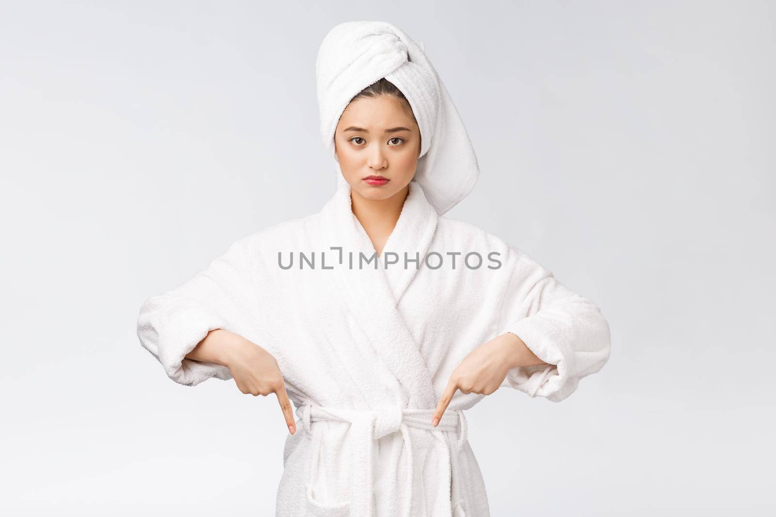 Young beautiful woman wearing shower towel after bath over isolated white background pointing with finger. by Benzoix