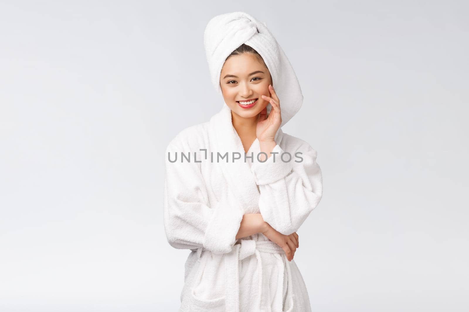 Portrait of a young happy asian lady in bathrobe.Isolated in white background