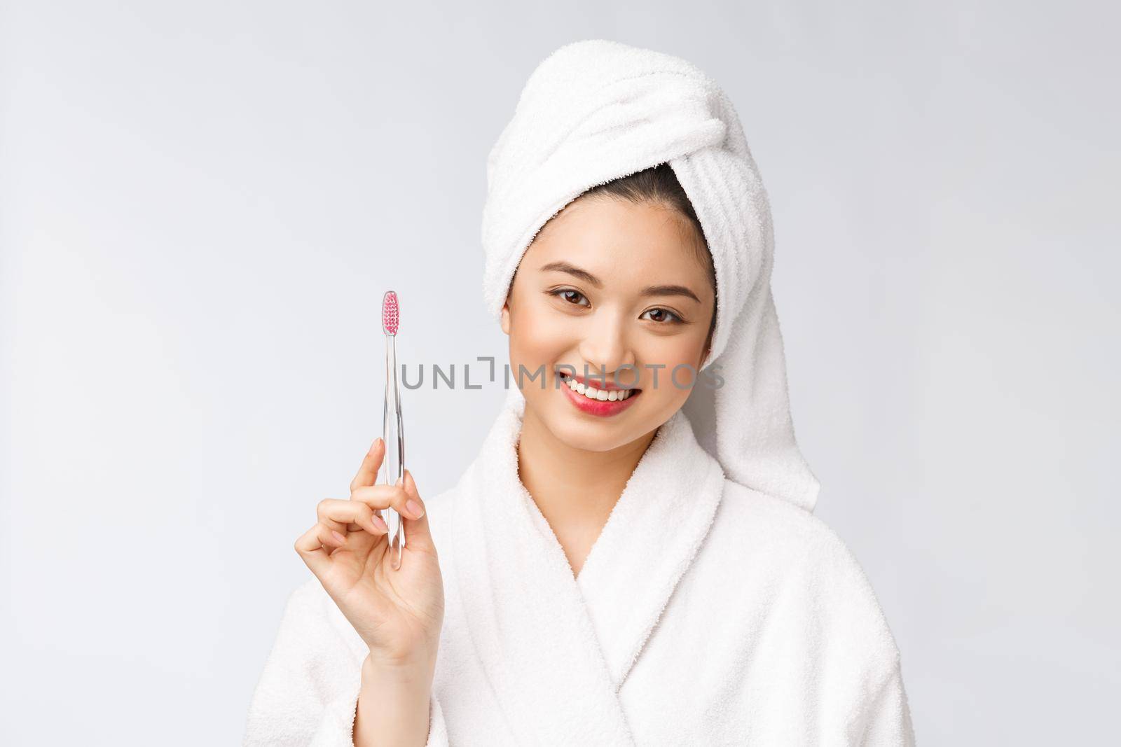 Asian happy woman with toothbrush in bathrobe morning mood by Benzoix