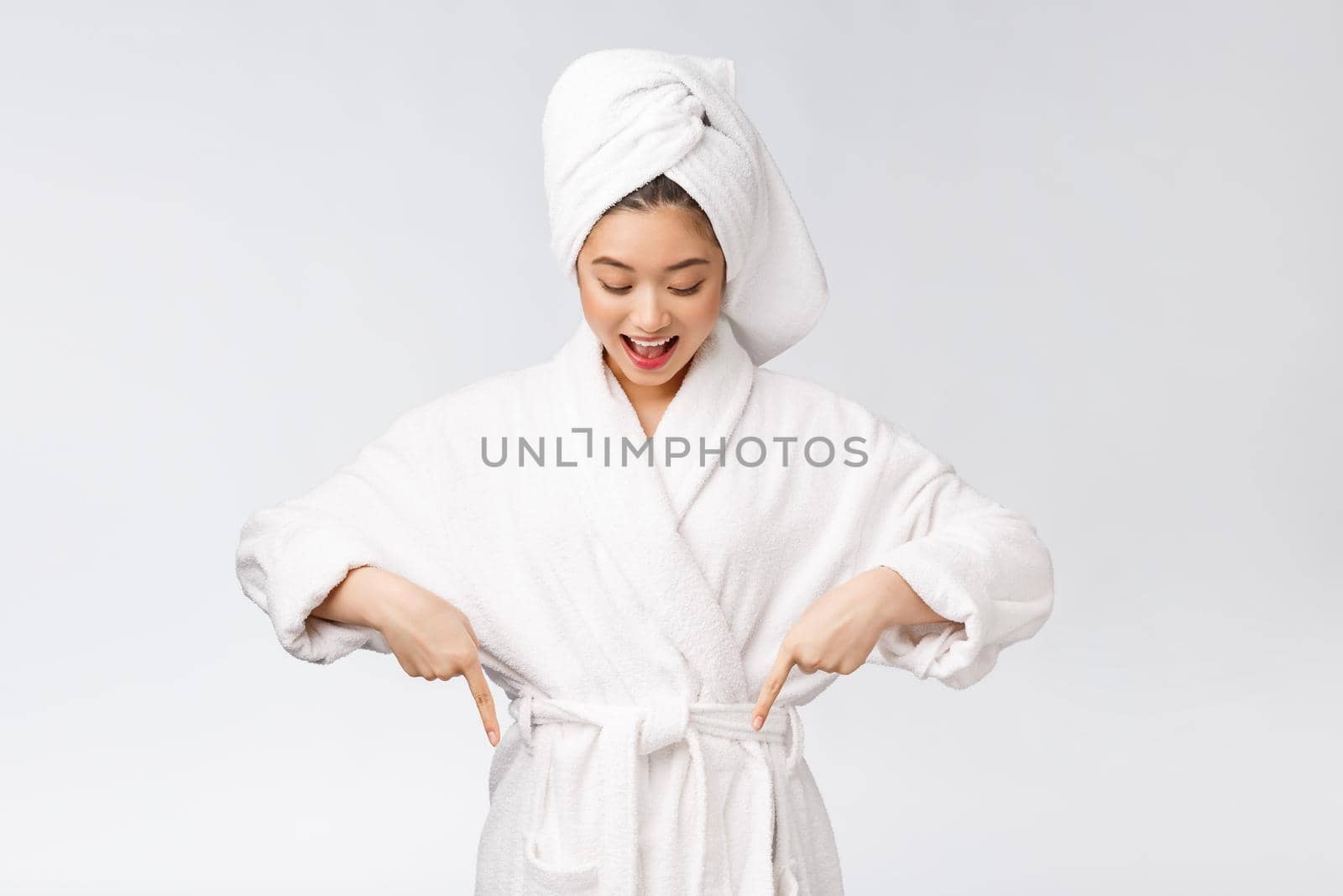Beauty portrait of young woman showing and pointing finger to empty copy space, asian beauty in bathrobe