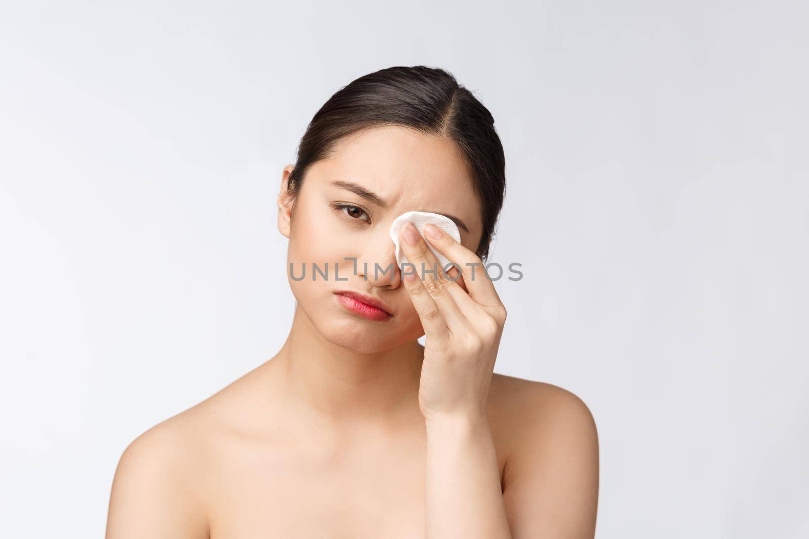 skin care woman removing face makeup with cotton swab pad - skin care concept. Facial closeup of beautiful mixed race model with perfect skin