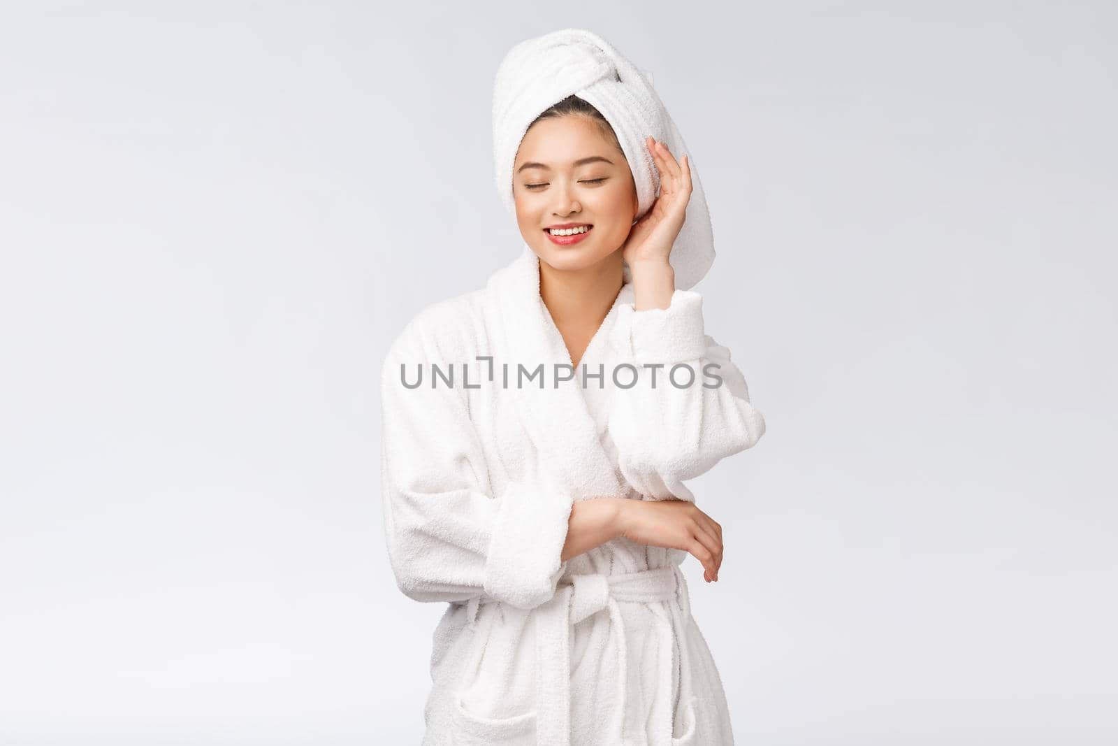 Portrait of a young happy asian lady in bathrobe.Isolated in white background. by Benzoix