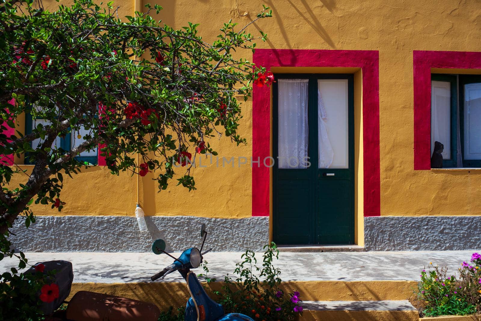 View of a typical colorful house of Linosa, colored red and orange with green door
