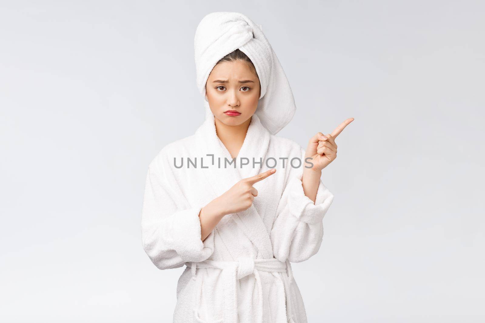 Young beautiful woman wearing shower towel after bath over isolated white background pointing with finger. by Benzoix