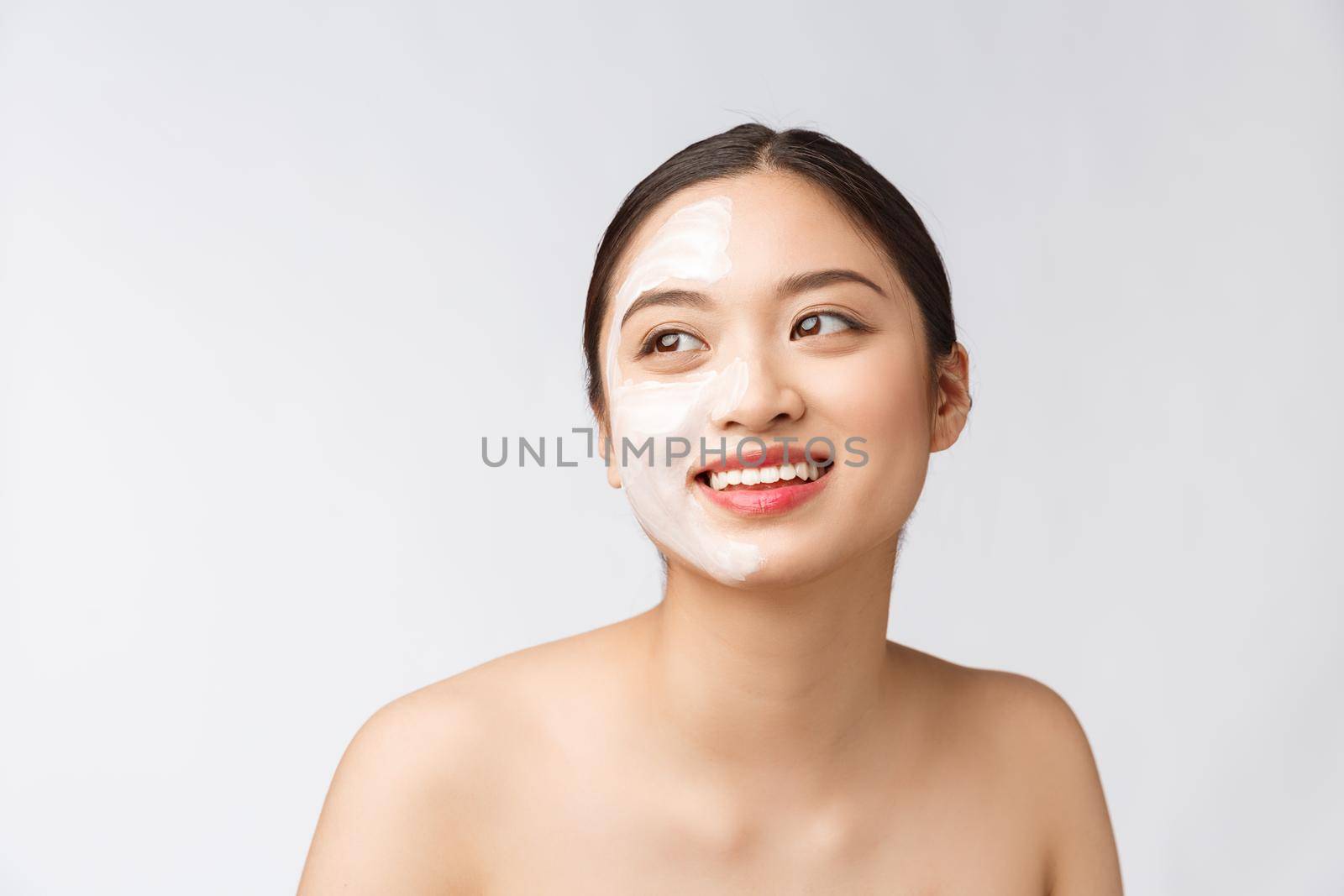 Charming pleasant woman applying cream on half face by Benzoix