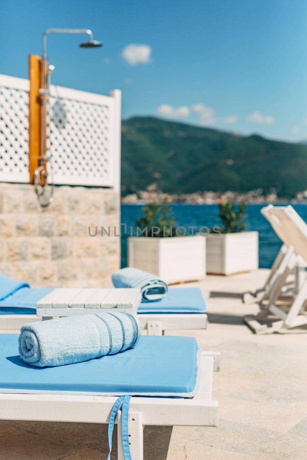 Blue beach towel on sun loungers on the beach near the sea. by Nadtochiy