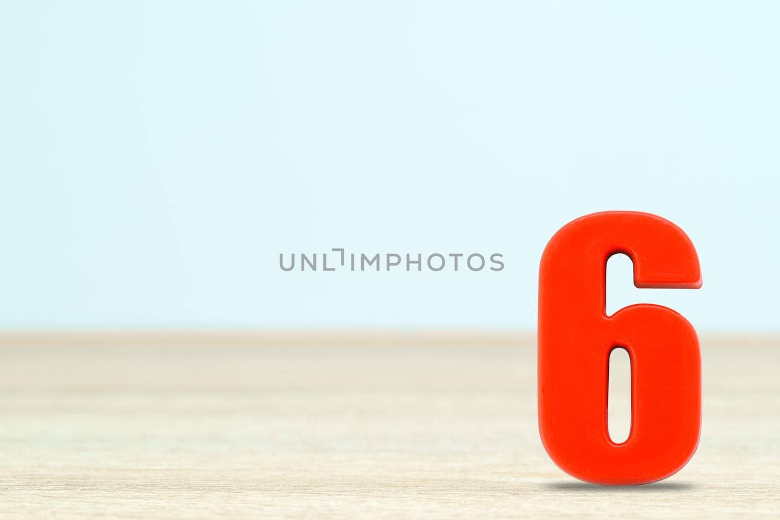 Shot of a number six made of red plastic on table with copy space