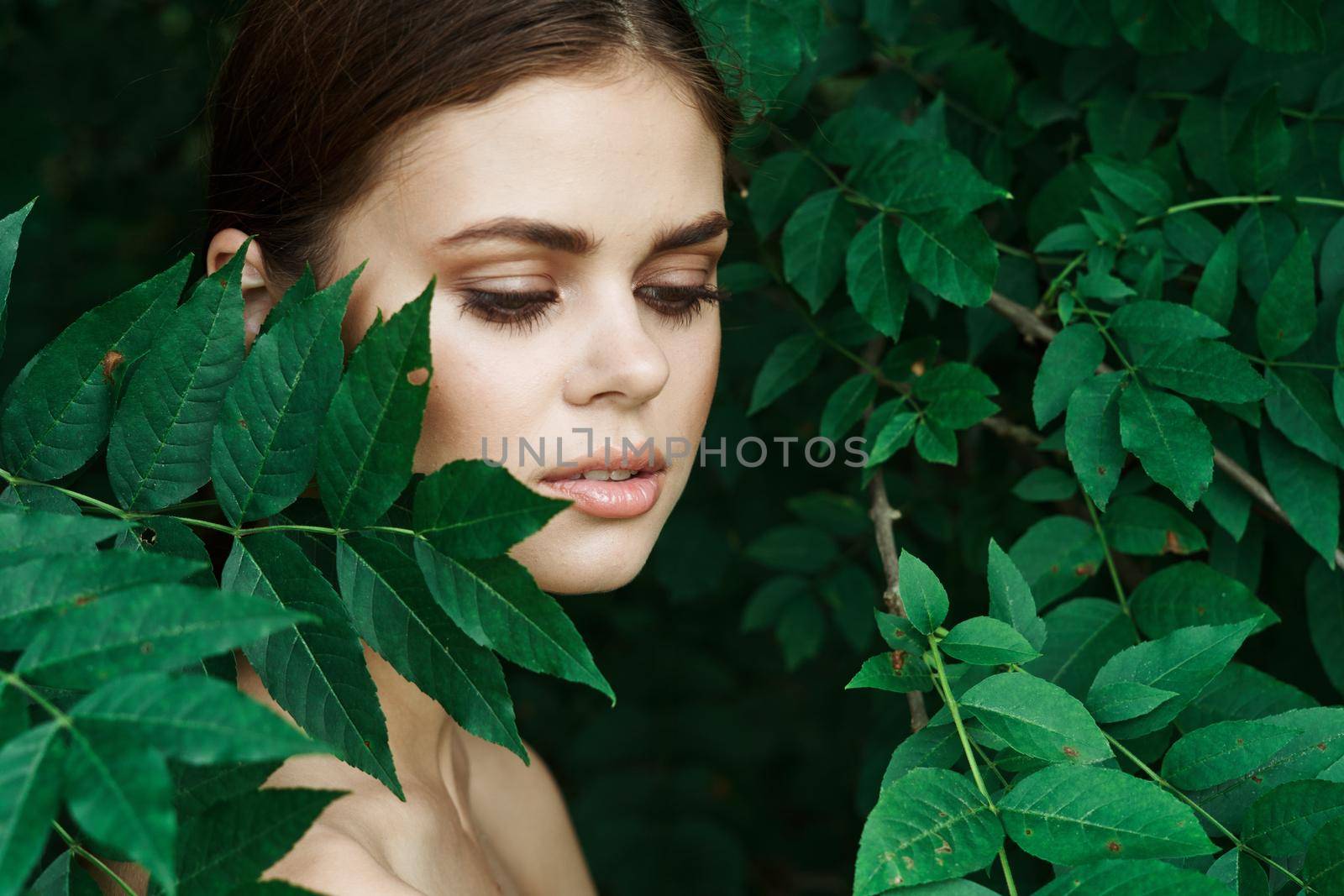 portrait of a woman green leaves clean skin nature summer model. High quality photo