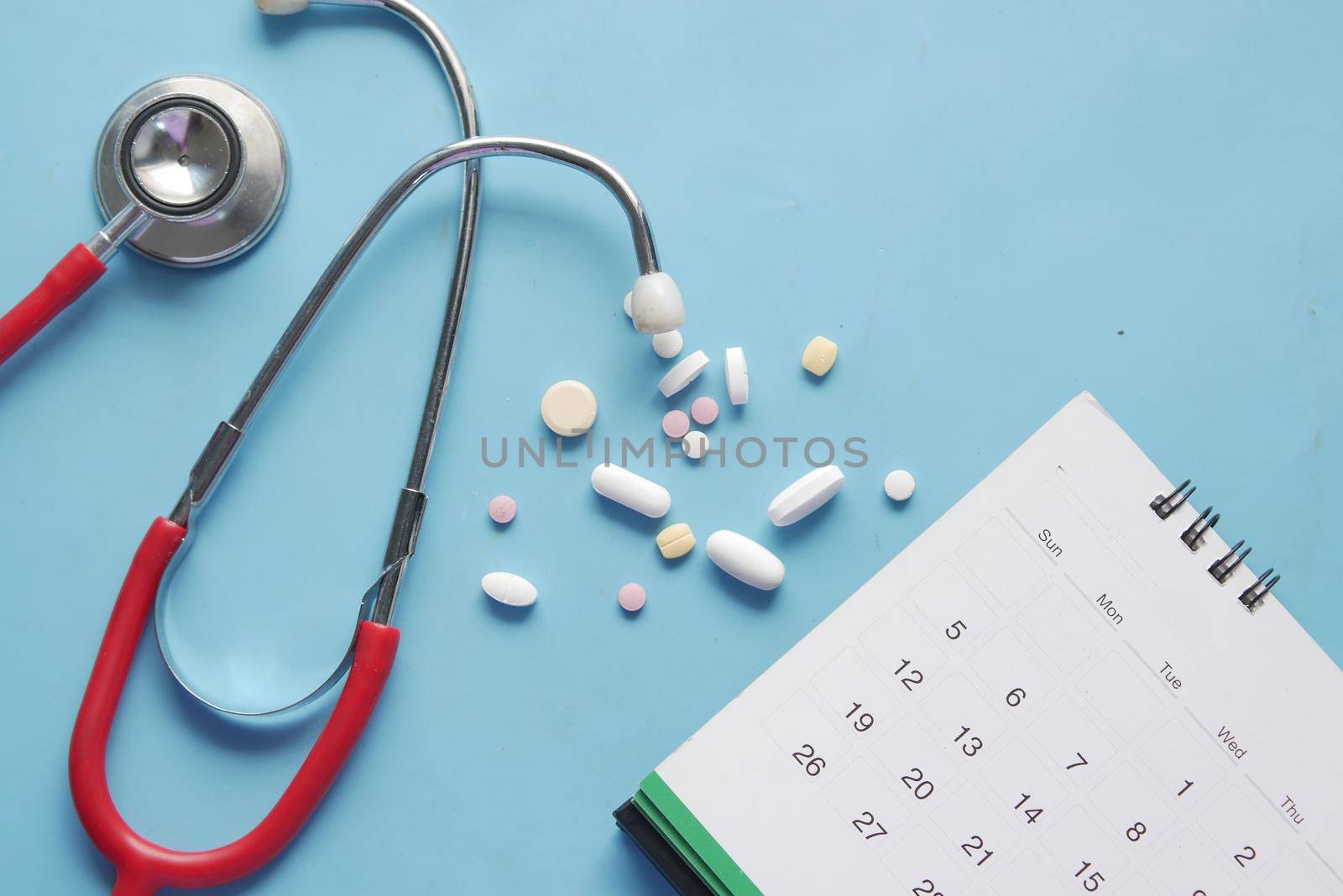 top view of pills and stethoscope on calendar , by towfiq007