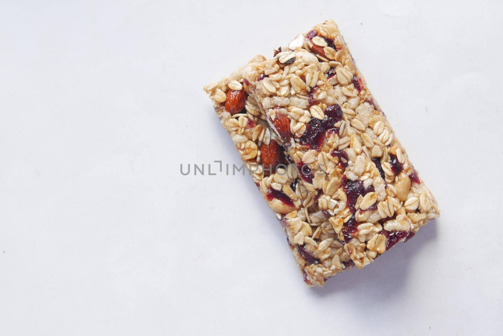 Almond , Raisin and oat protein bars on white background .,