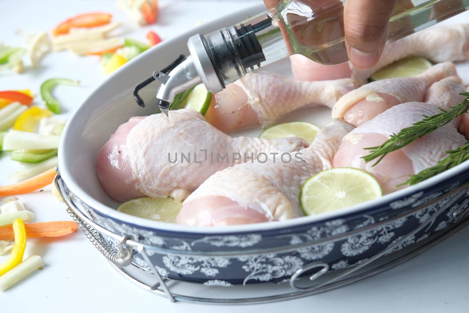 putting olive oil on raw chicken drumstick