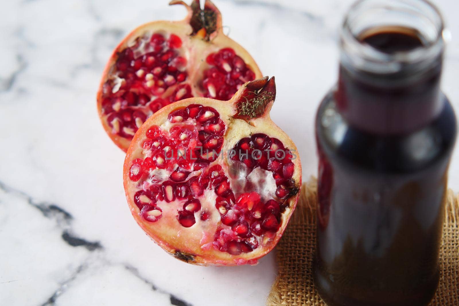 glass on pomegranate juice and fresh fruits on red background