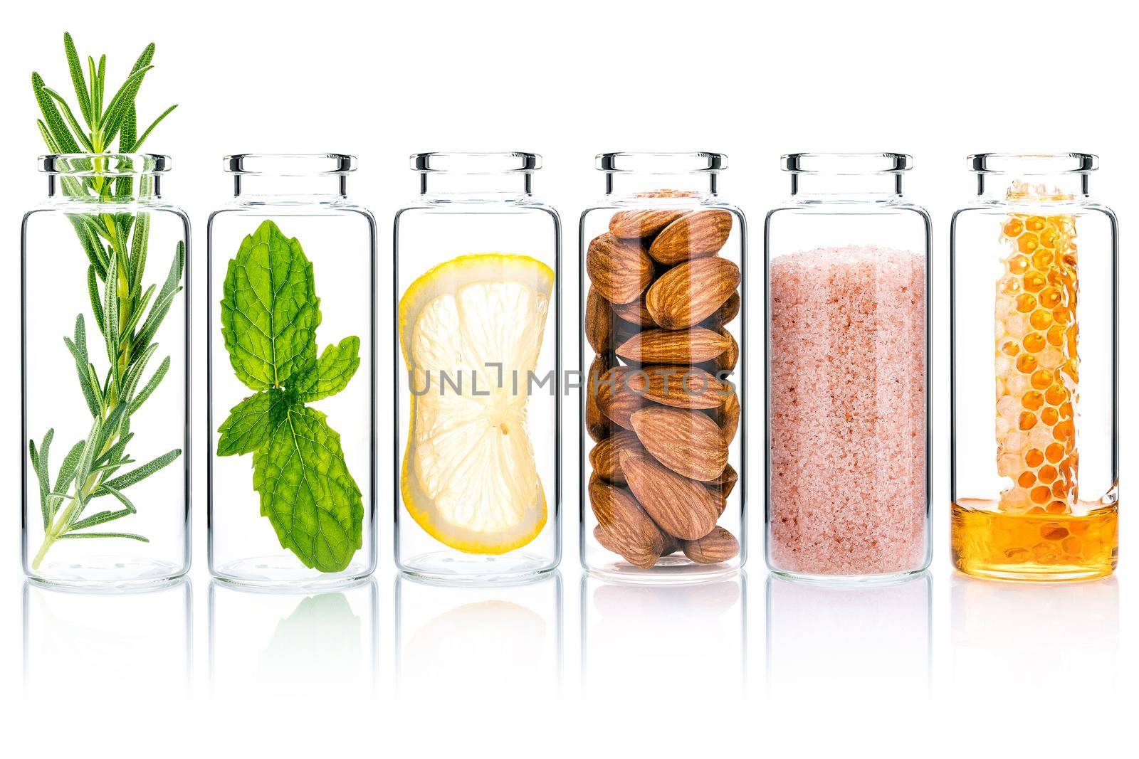The glass bottle of homemade skin care and body scrubs with natural ingredients isolated on white background.