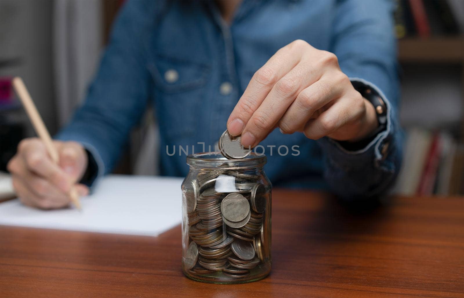 Business woman save money in glass jar for investment