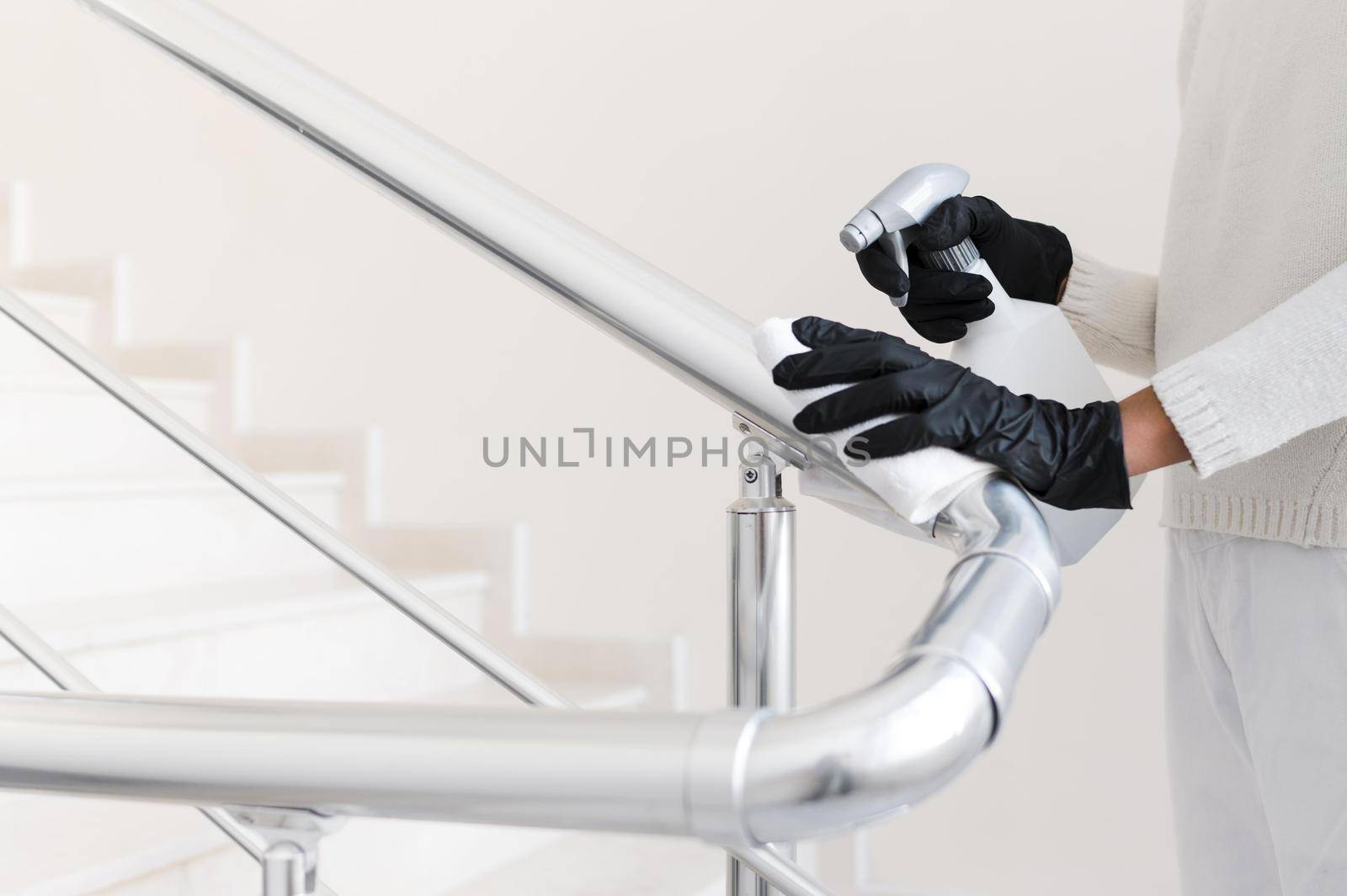 hands with gloves disinfecting hand rail. High quality beautiful photo concept by Zahard