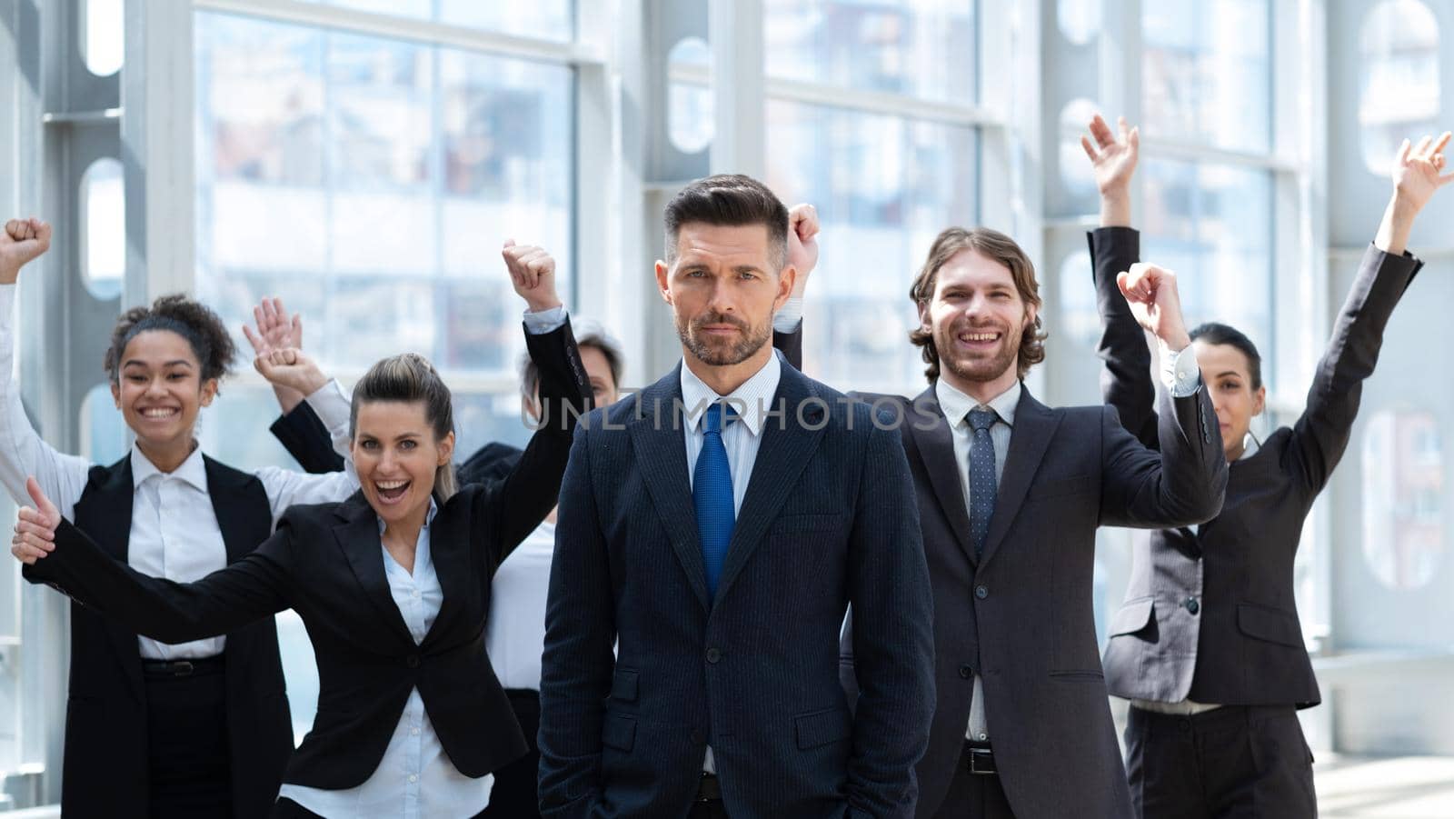 Business winners team. Group of happy people in formal wear celebrating, gesturing, keeping arms raised and expressing positivity