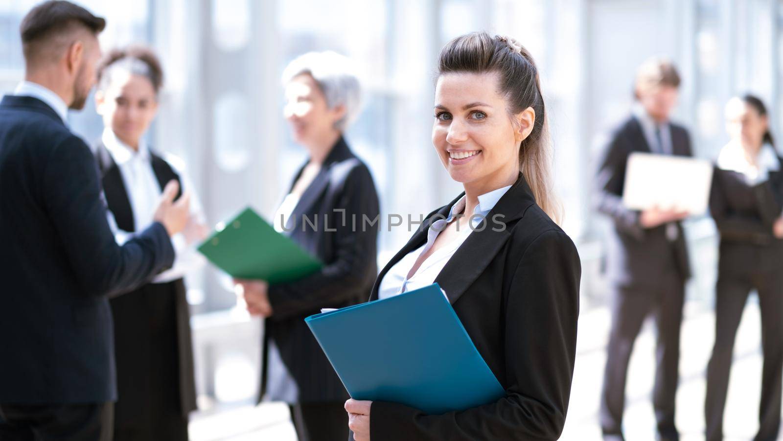 Business woman in front of colleagues by ALotOfPeople