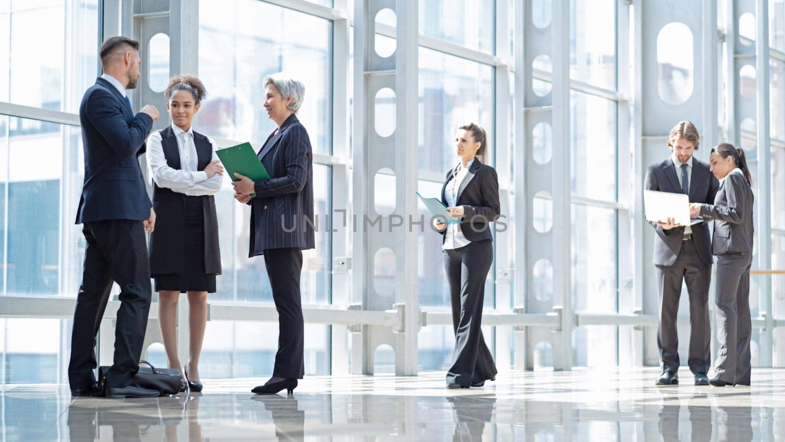Business peopl talking about documents in office lobby of modern building