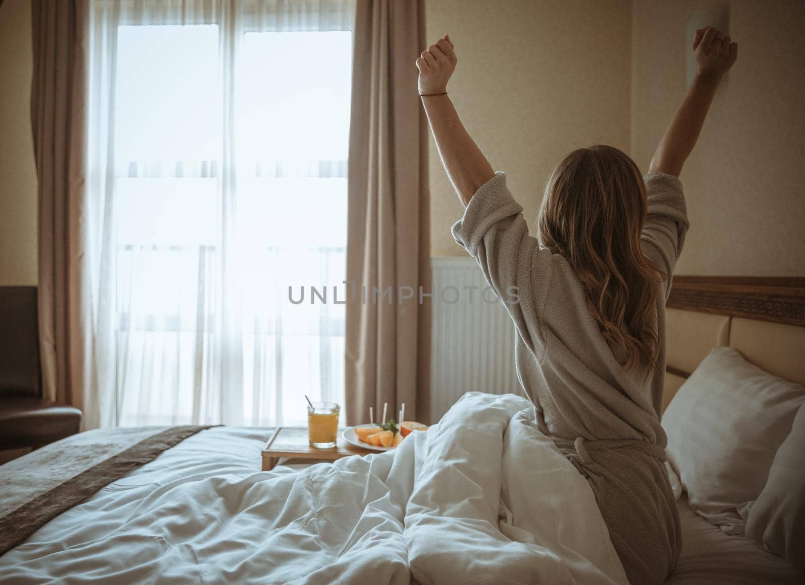 rear view woman stretching body after awakening bed. High quality beautiful photo concept by Zahard