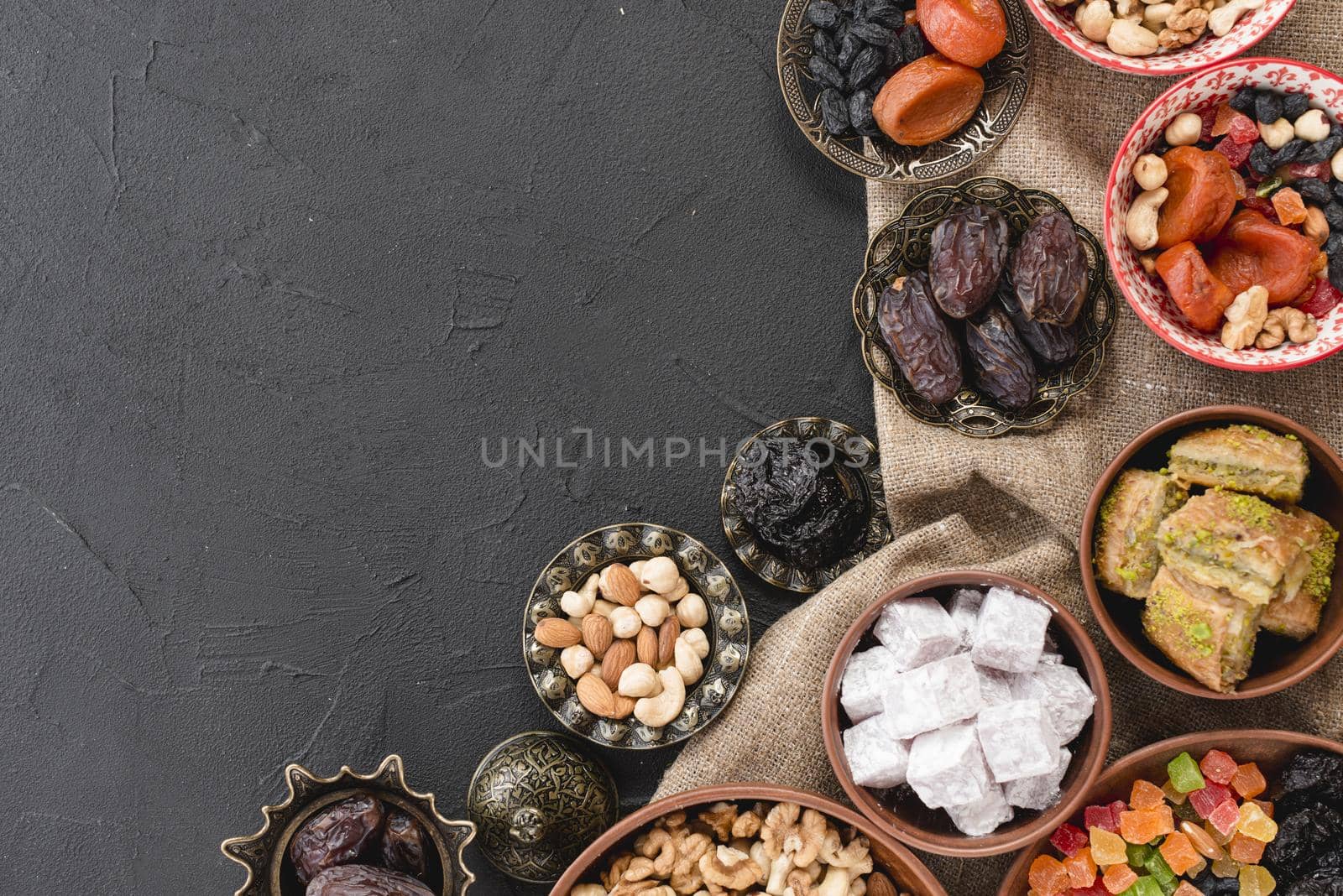 traditional ramadan dessert nuts metallic earthen bowl black backdrop. High quality beautiful photo concept by Zahard