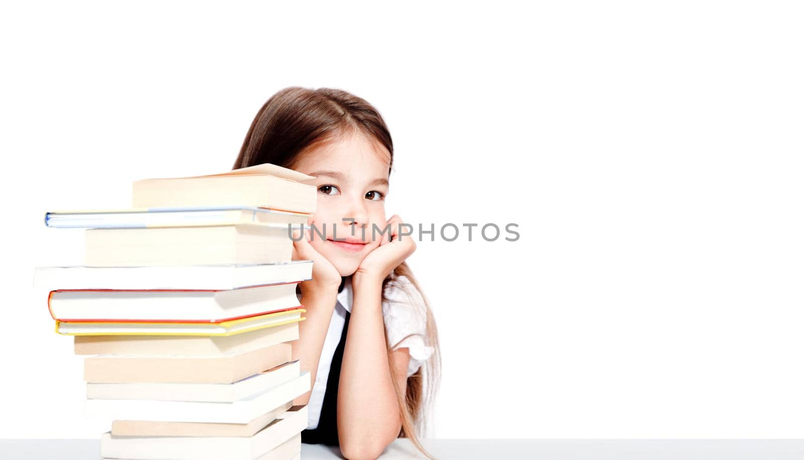Young cute girl sitting at the table and reading a book by Taut