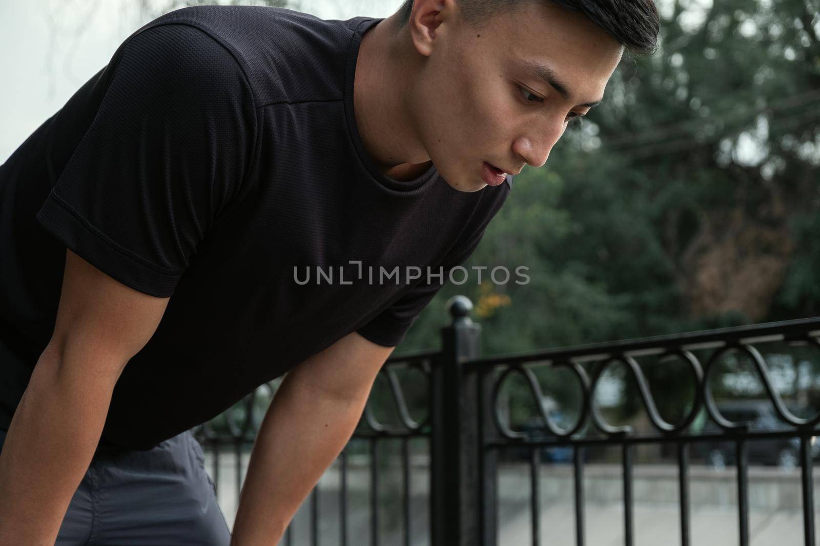 Shot of a handsome young man taking a moment to catch his breath after a morning run in the city