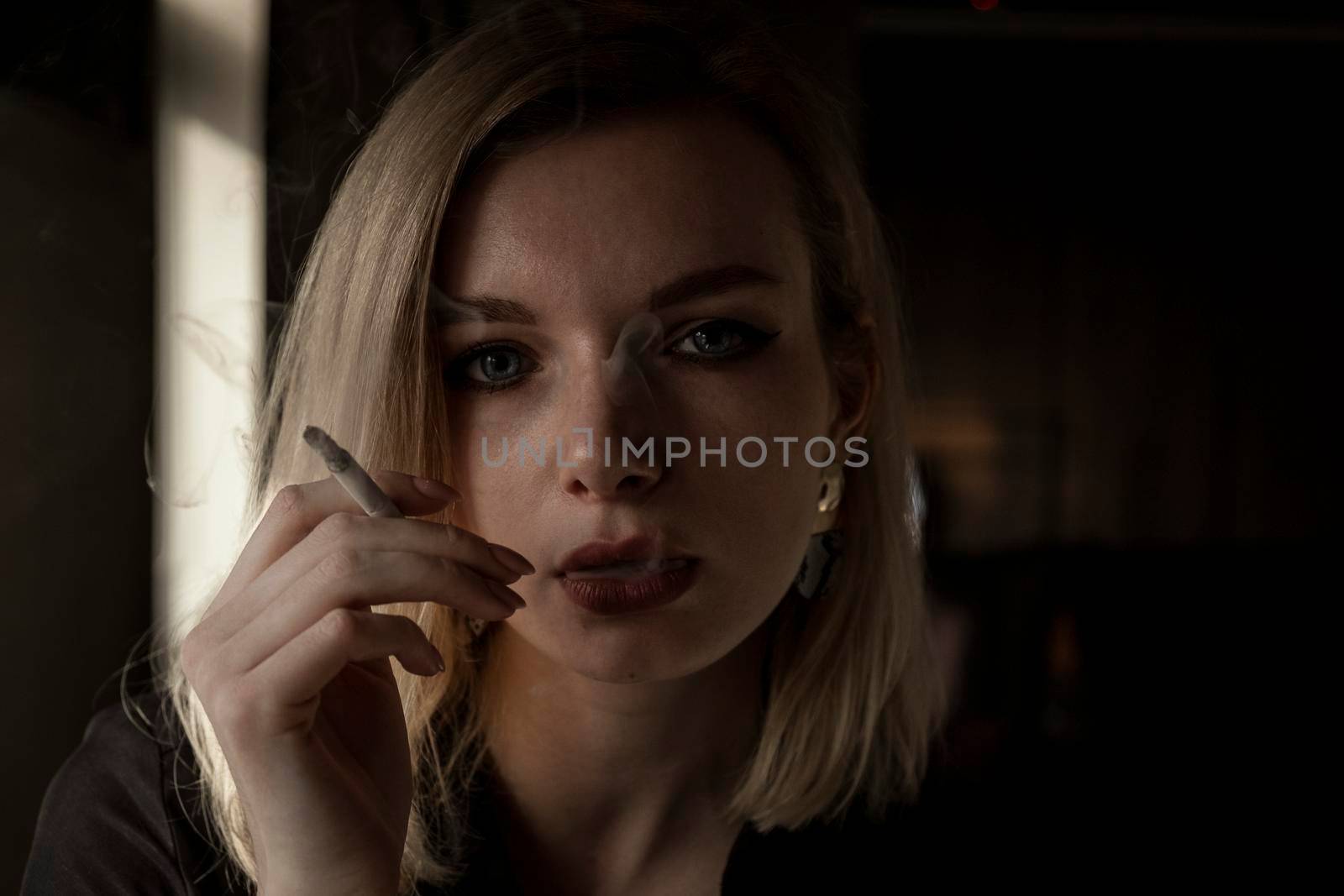 Close-Up Of Young Woman Smoking Cigarette By Window