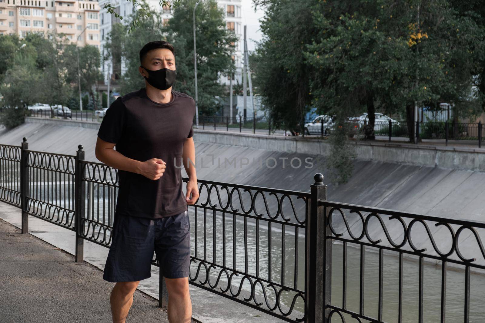 An Asian man running in the city, in the evening. Kazakhstan