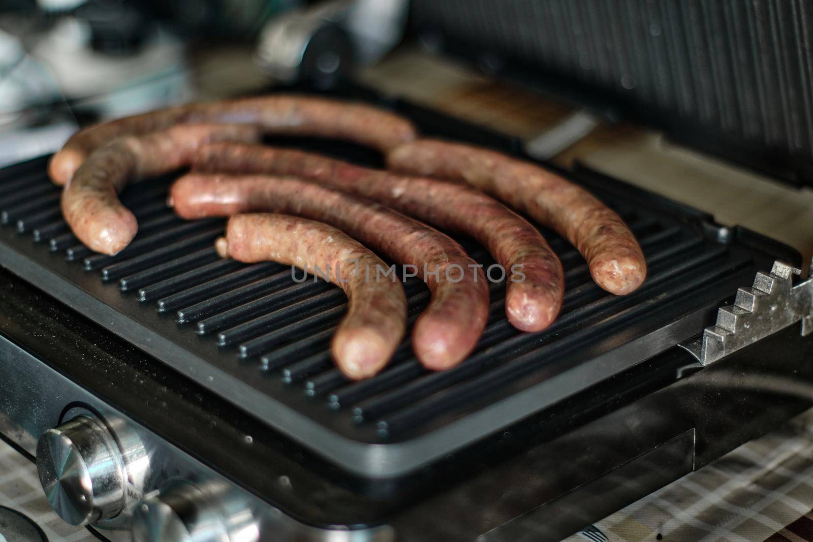 Grilled raw sausages are cooked, close up shot