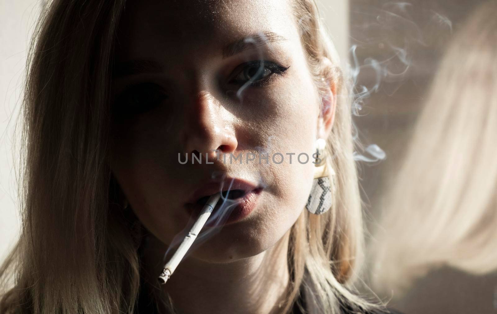 Close-Up Of Young Woman Smoking Cigarette By Window
