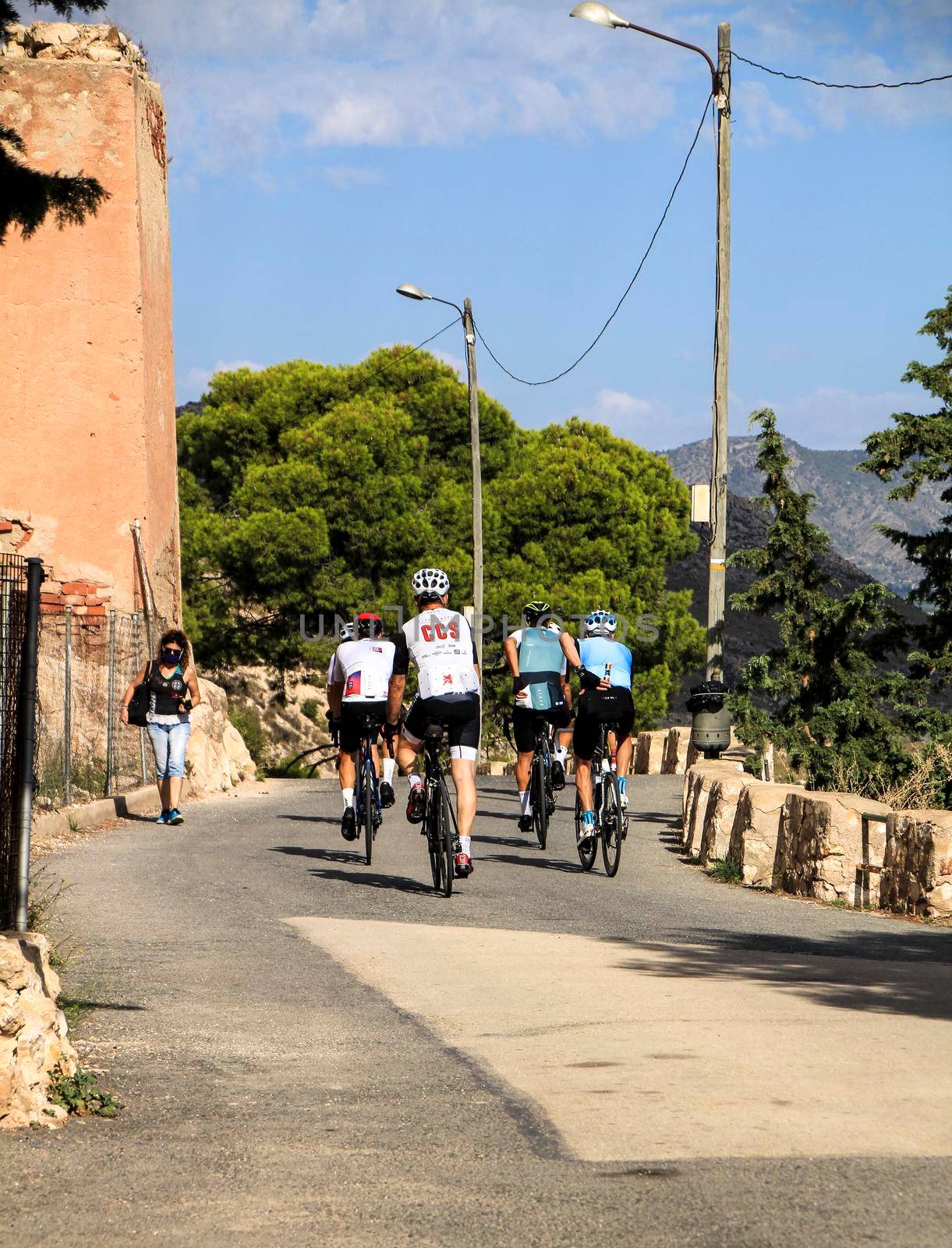 Alicante, Spain- September 18, 2021: Group of cyclists riding on a mountain road in Alicante on a sunny day of summer