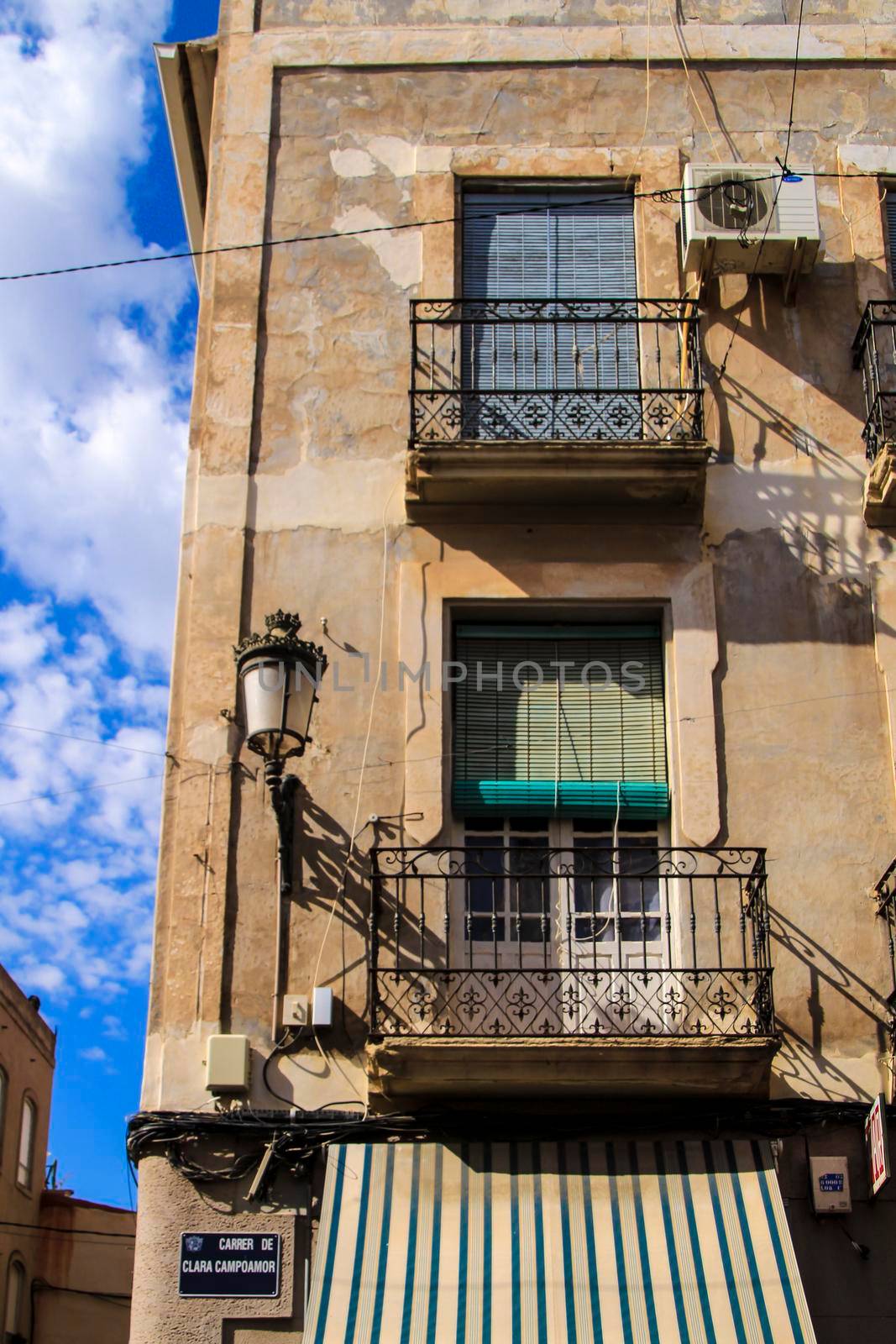 Novelda, Alicante, Spain- September 18, 2021: Old house facade with rusty balcony and blind in Novelda, Alicante.