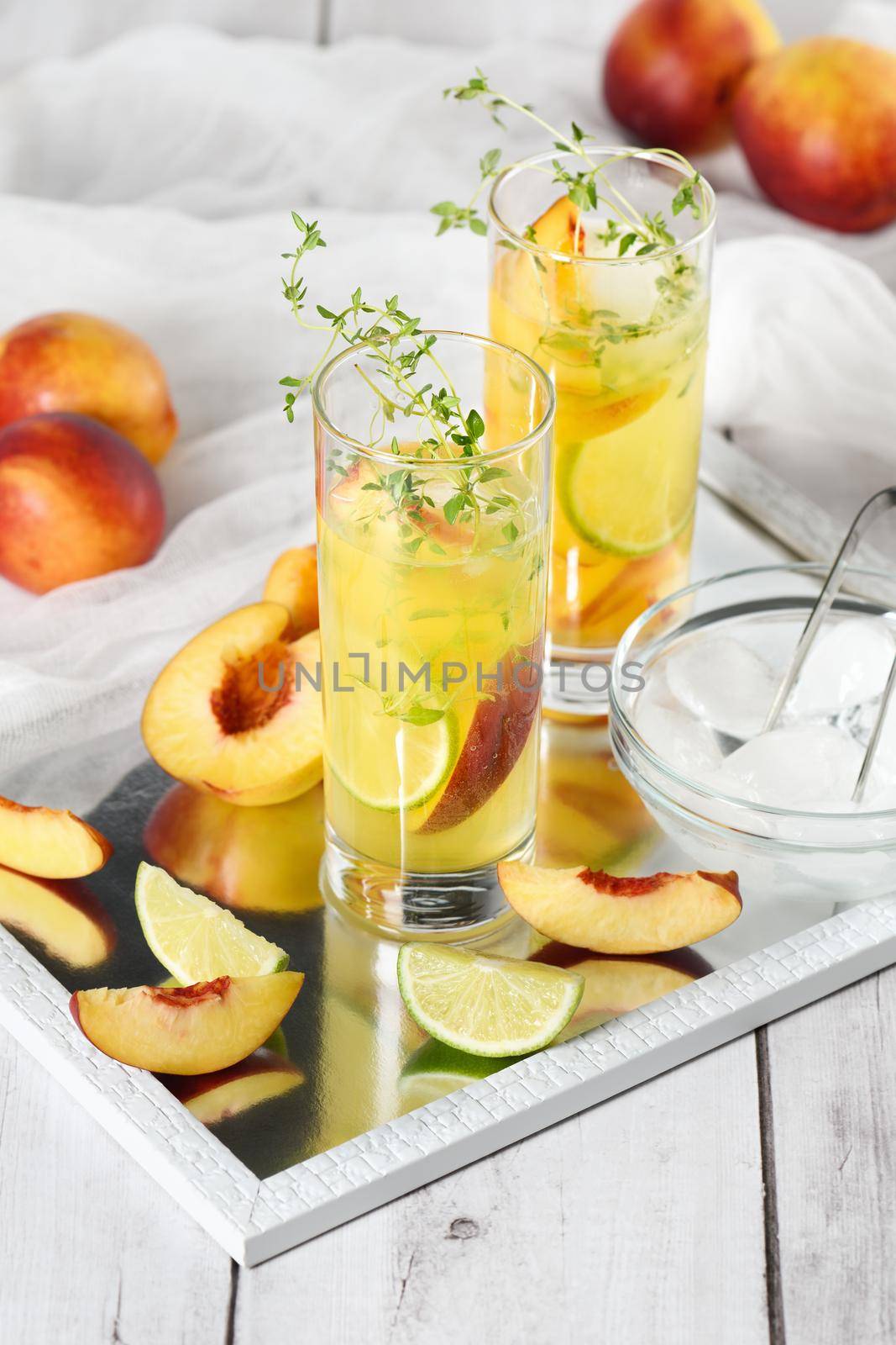 Peach summer cocktail. Refreshing organic non-alcoholic drink, lemonade with ripe nectarine, thyme and lime  