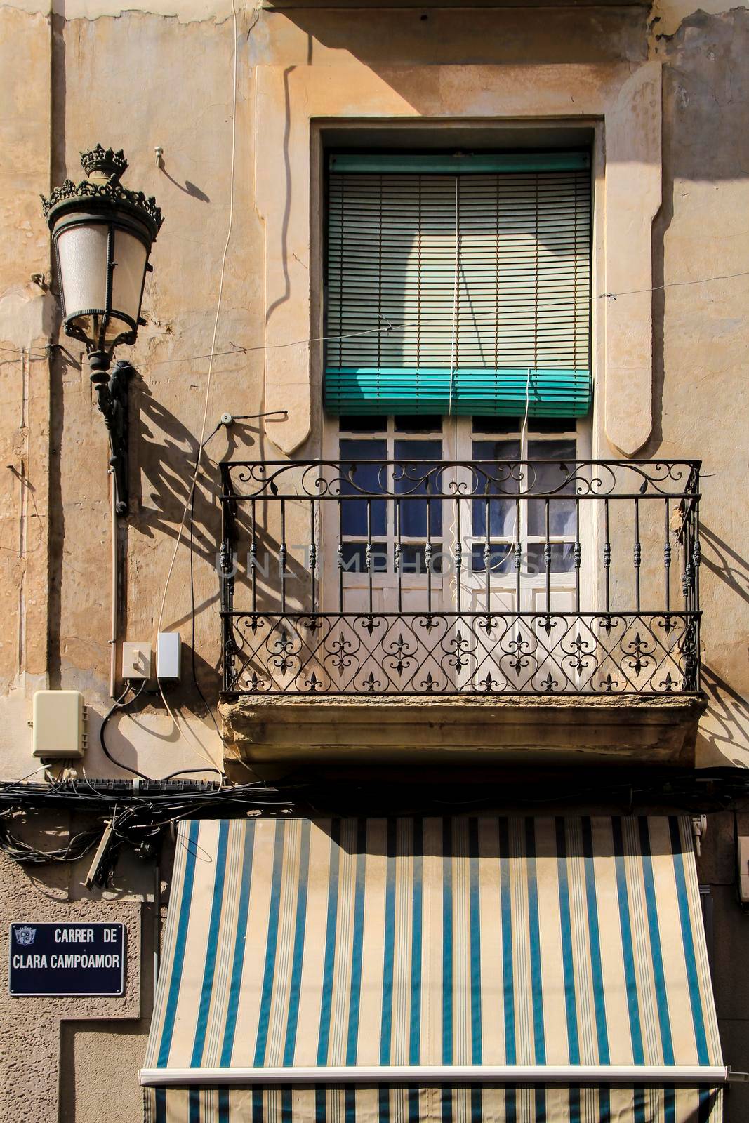 Novelda, Alicante, Spain- September 18, 2021: Old house facade with rusty balcony and blind in Novelda, Alicante.