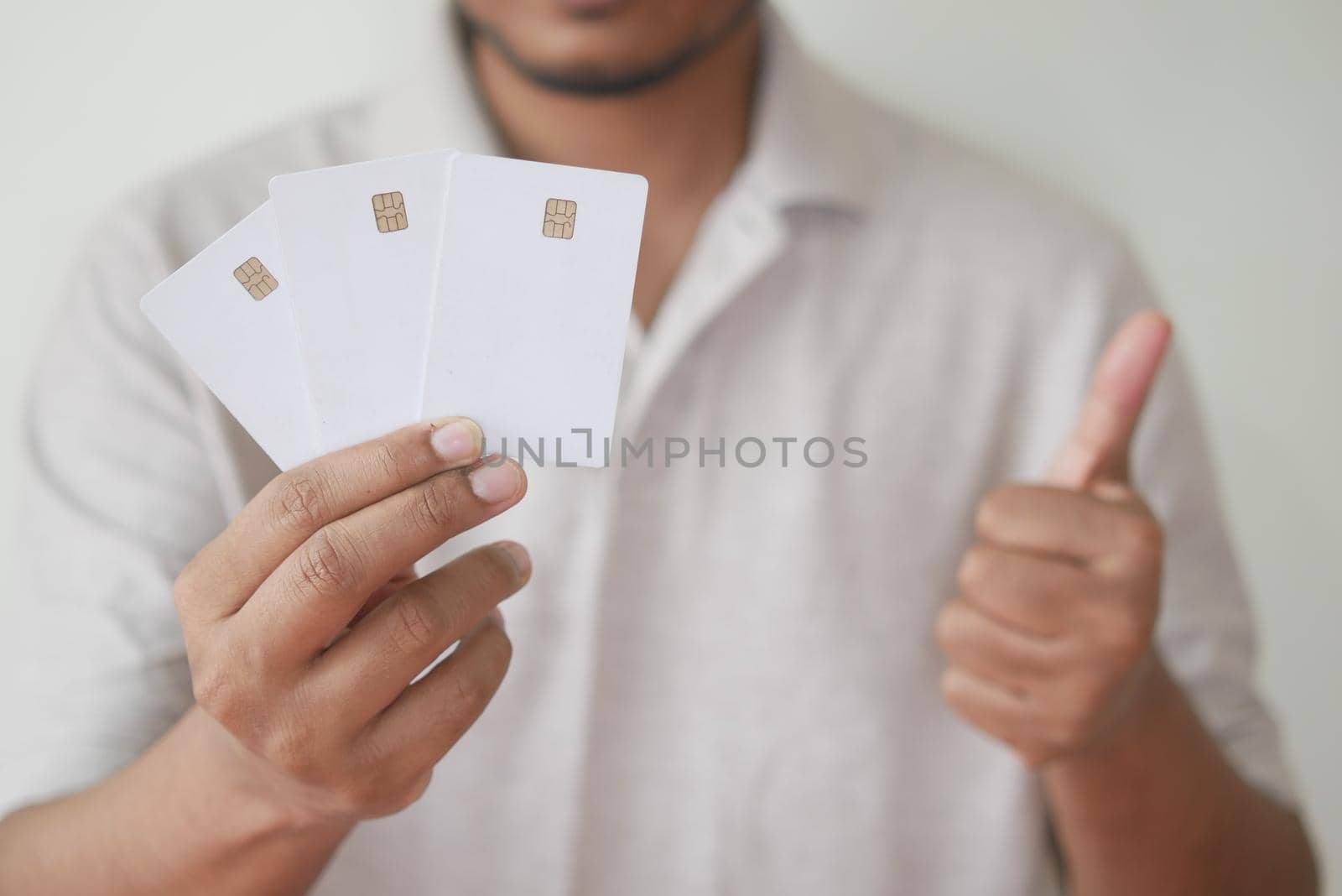 Man in casual dress showing credit card.