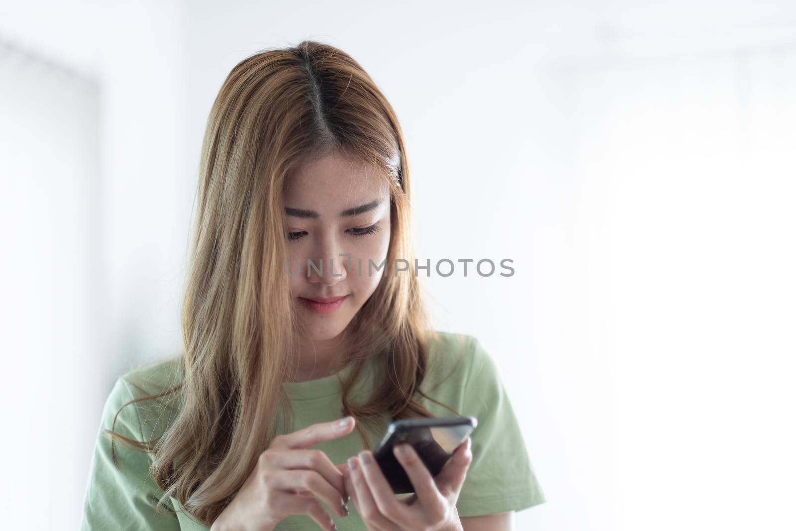 Cropped image of charming asian woman using mobile phone.