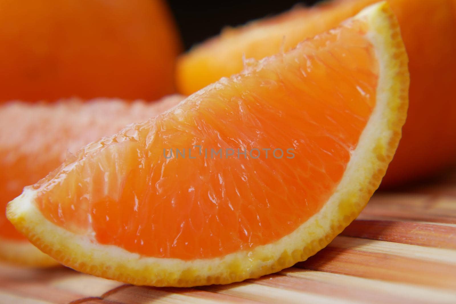 close up of slice of orange fruit on color background by towfiq007