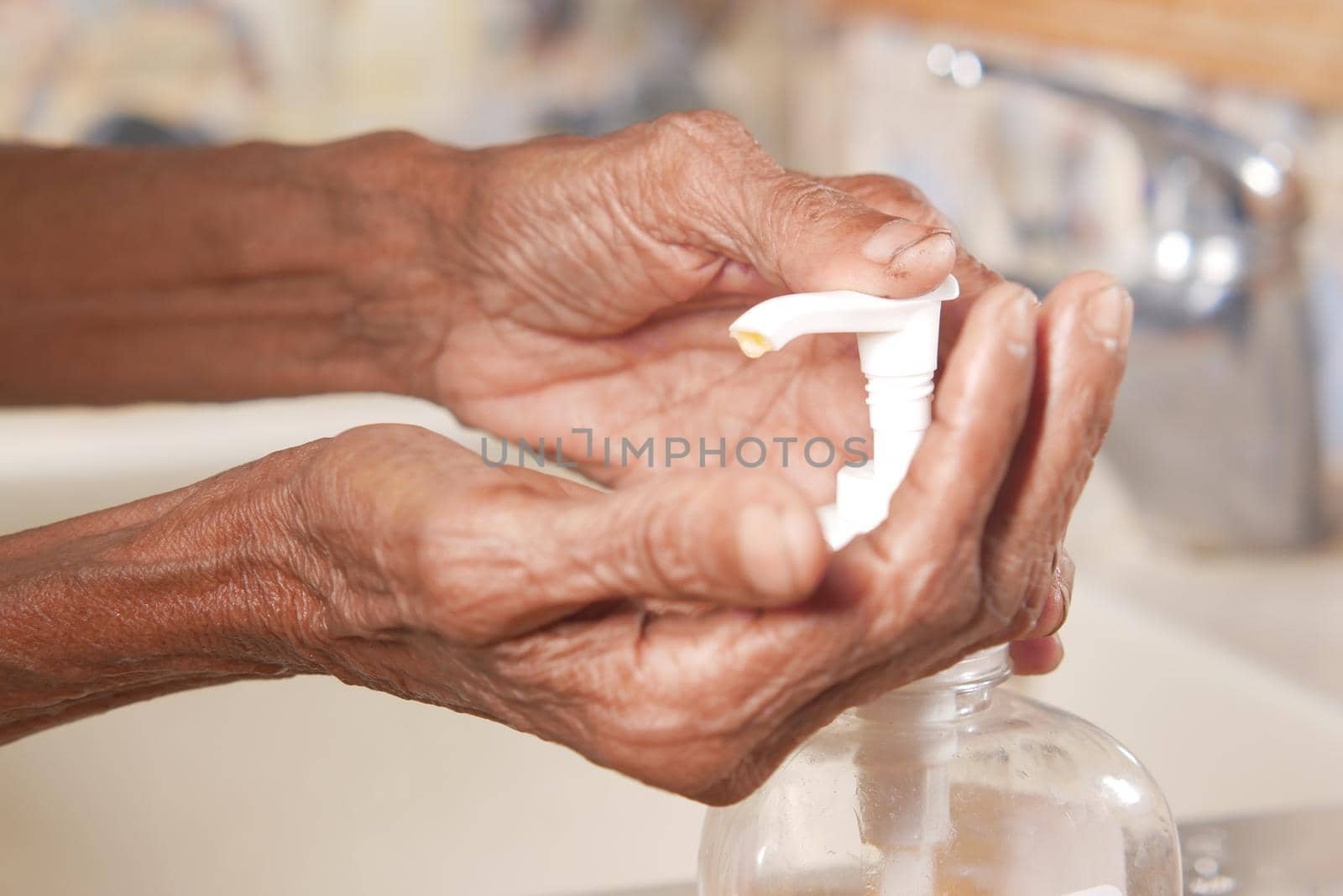 close up of senior women hand using sanitizer gel for preventing virus .