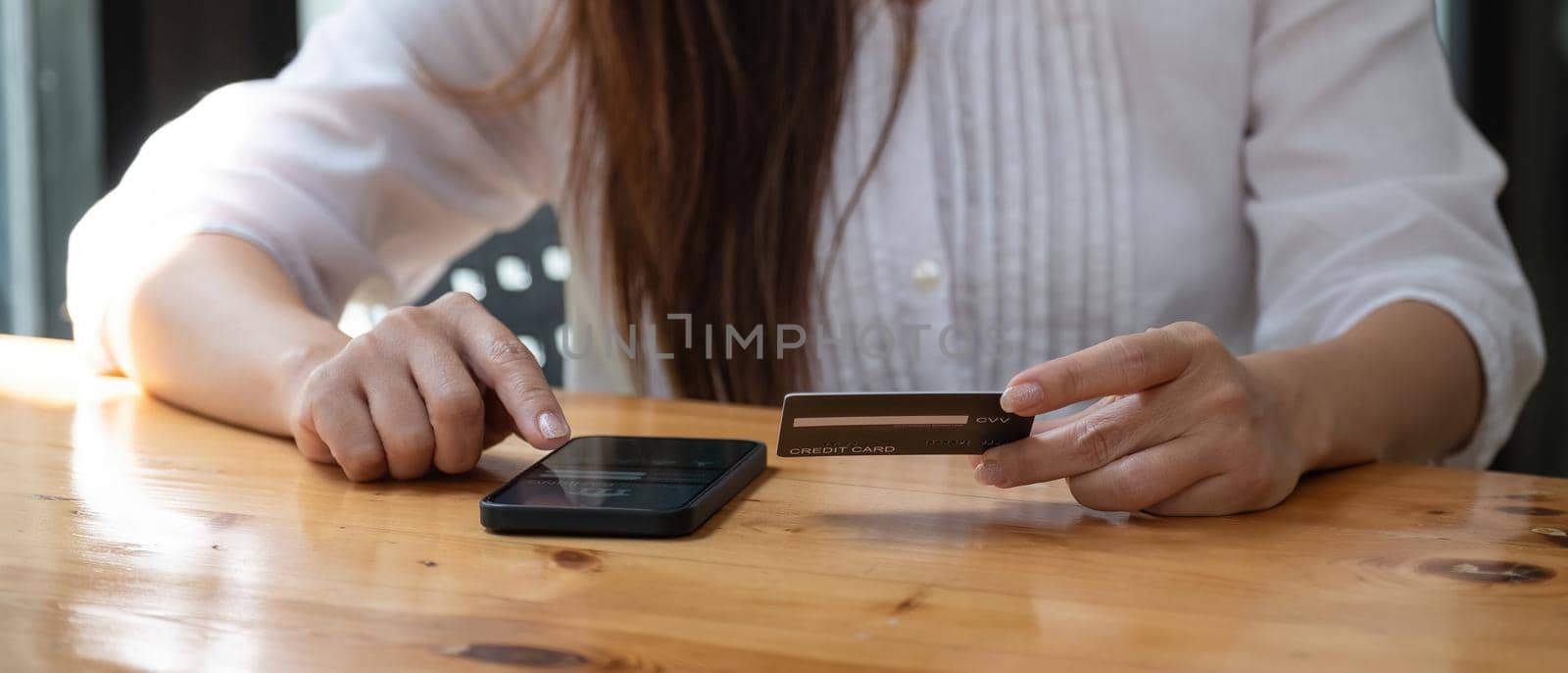 Hands holding credit card and using mobile phone. Online shopping