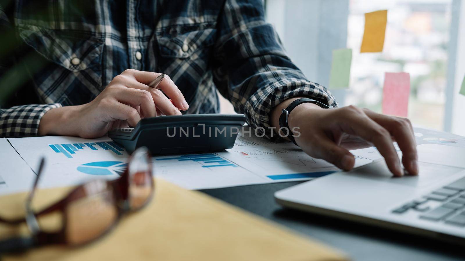 Business woman using calculator for do math finance on wooden desk in office and business working background, tax, accounting, statistics and analytic research concept. by nateemee