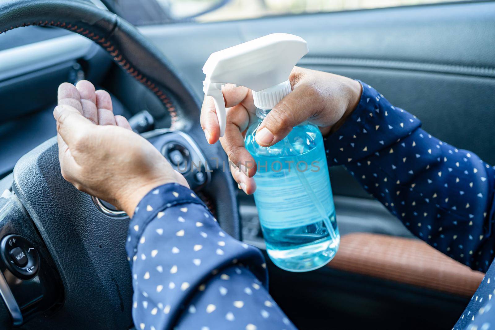 New Normal, Asian working woman washing hand by press blue alcohol sanitizer gel for protect safety Coronavirus in car.