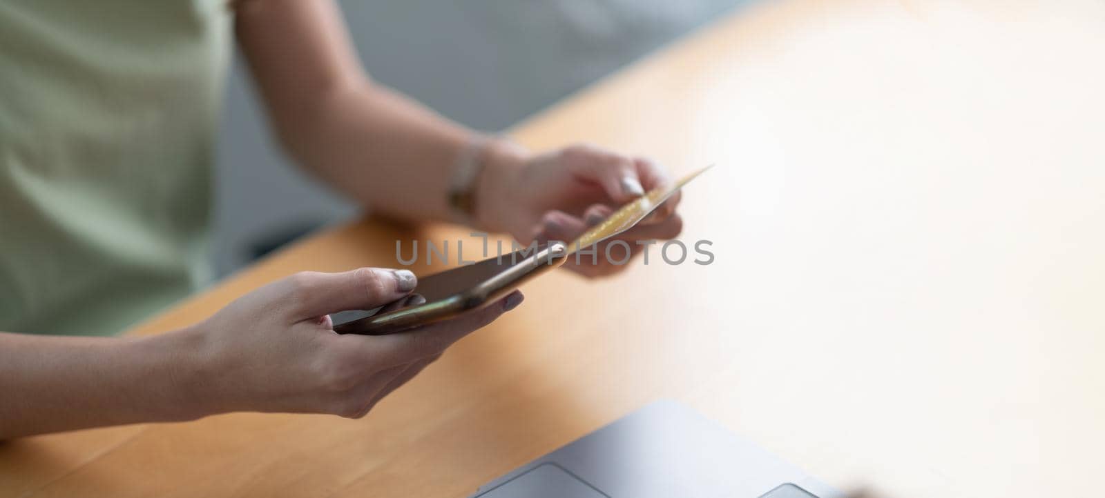 Close up hand of woman using credit card and mobile phone for online shopping and internet payment via mobile banking app